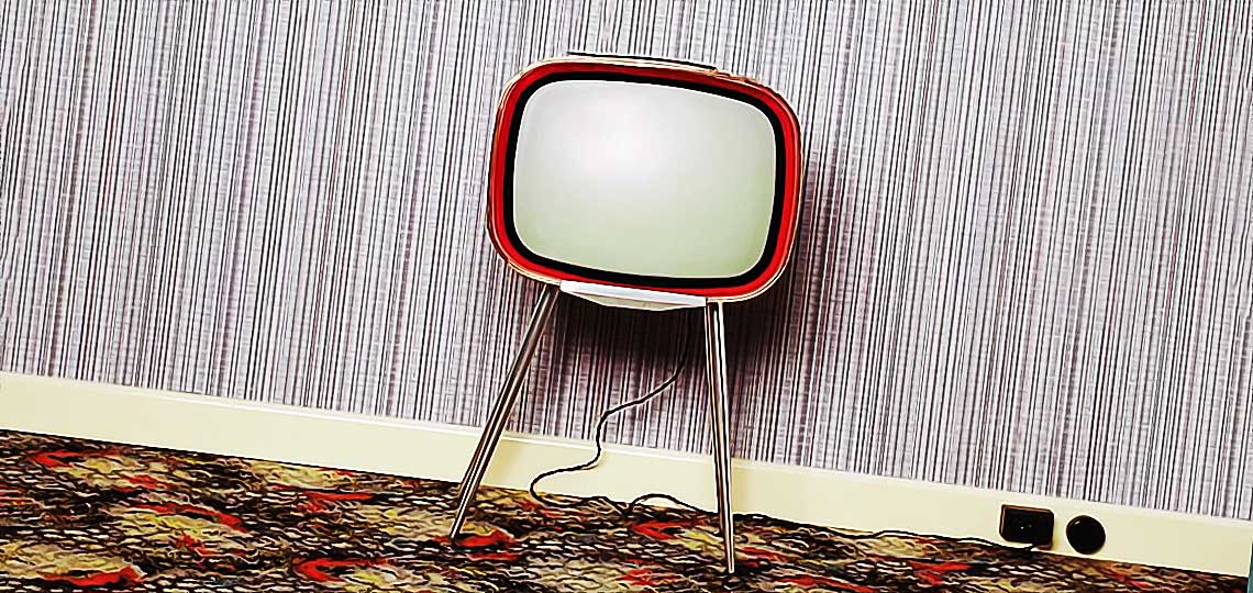 Télévision vintage sur pieds dans un salon.