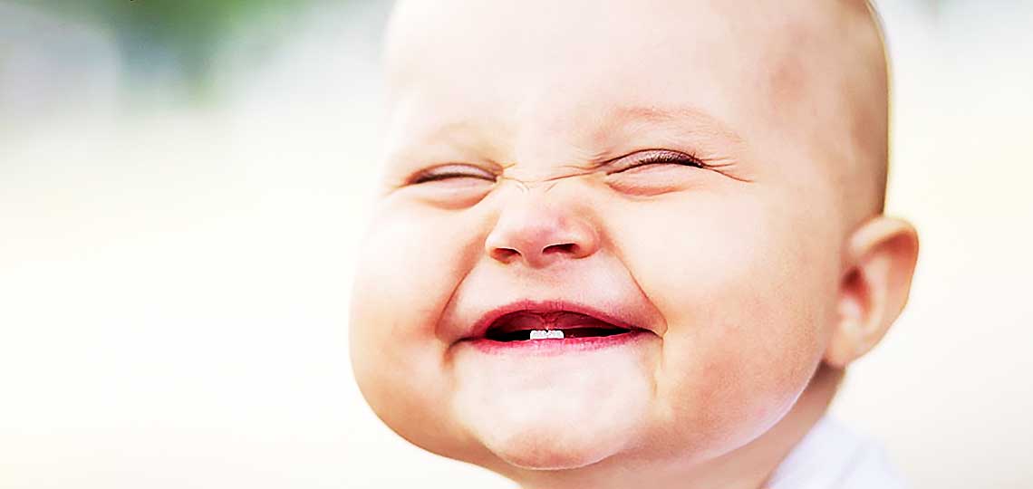 Bébé souriant à pleines dents.