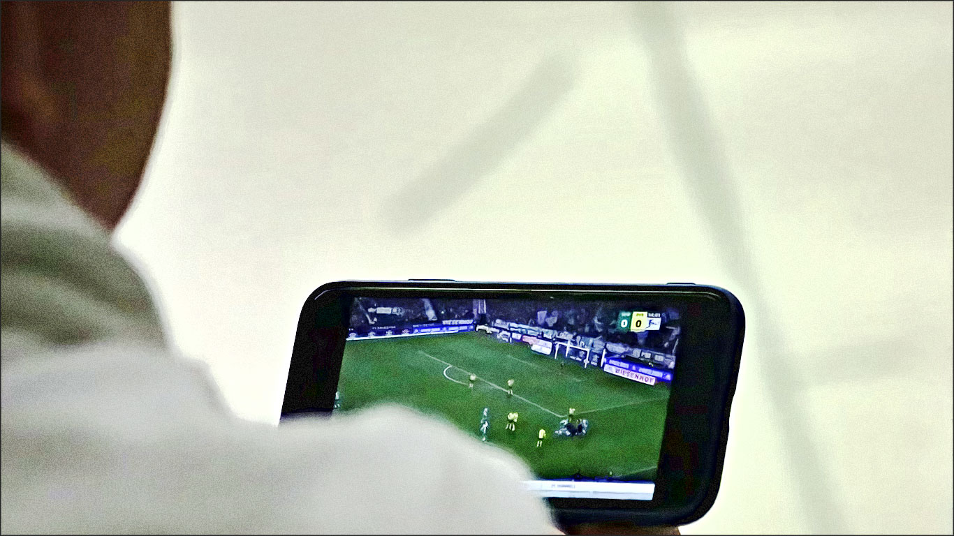 homme regardant match foot sur telephone